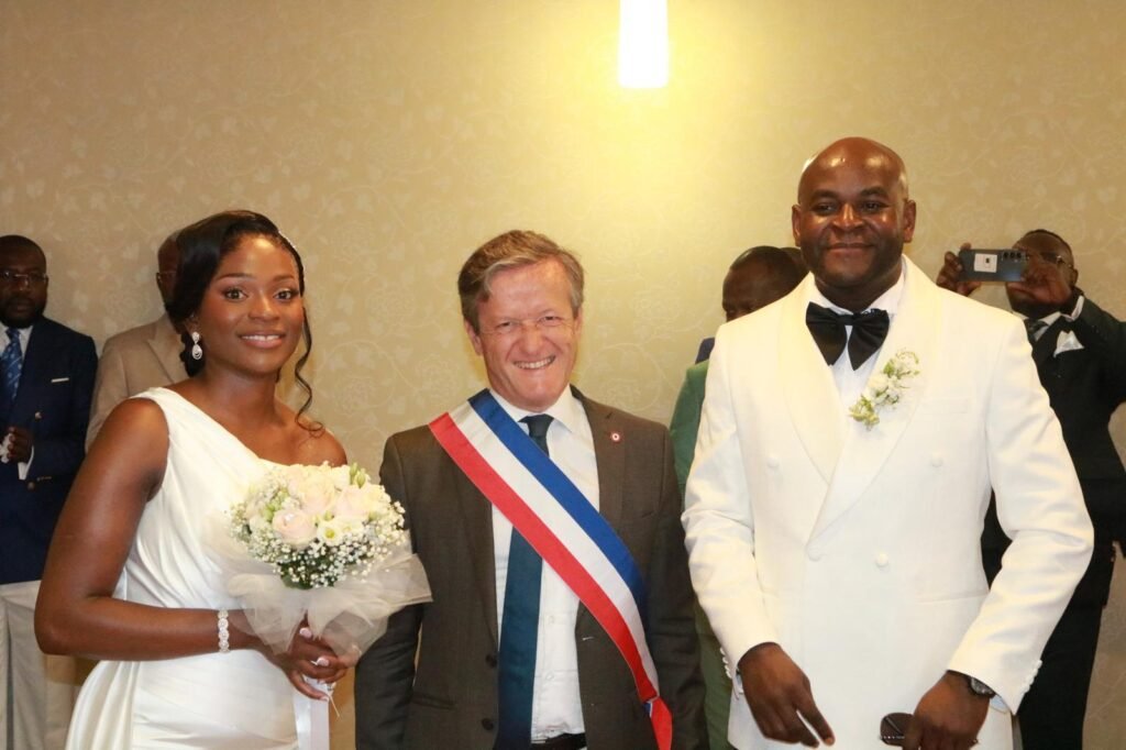 Norélia et Éric le jour de leur mariage, entourés de l'officiant